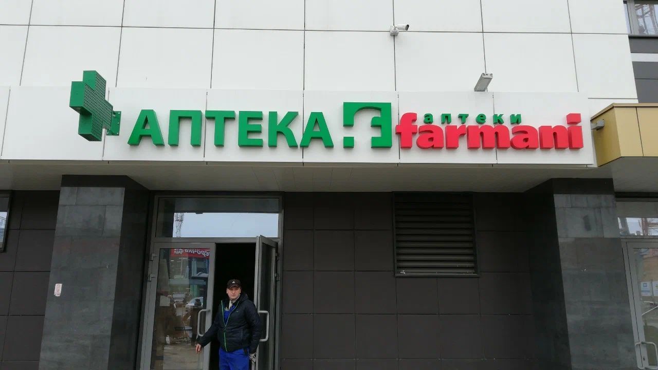 Фасад аптеки с зелёными объёмными буквами «АПТЕКА», названием farmani и аптечным крестом